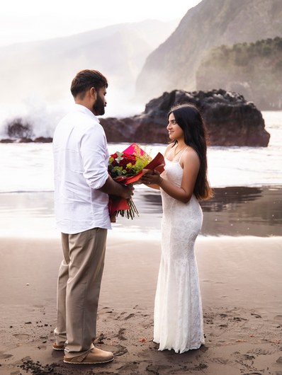 Man giving flowers to his partner on Seixal Beach after a romantic proposal in Madeira