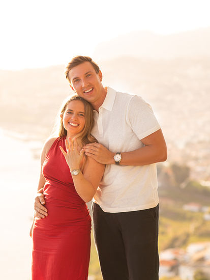 Happy couple celebrating their engagement with sunset views in Madeira