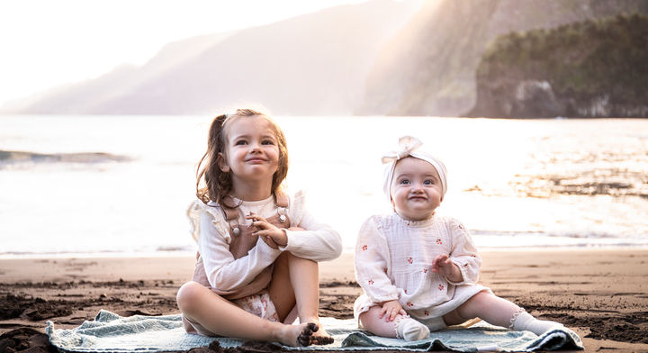 Sisters enjoying a beach family photography session in Madeira during golden sunset light