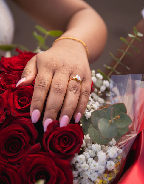 engagement moment with red roses and ring close up in romantic proposal setup
