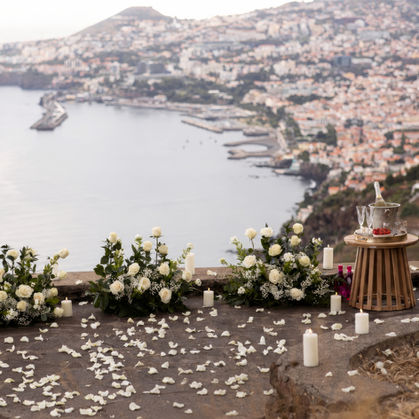 Luxury floral proposal decoration in Madeira with elegant white flower arrangements, romantic candlelight, and panoramic cliffside ocean views.