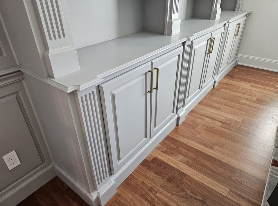 Light grey painted cabinets with fluted trim and brass handles