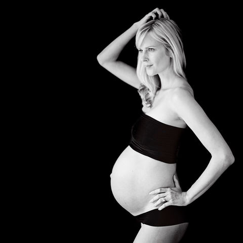 Black-and-white maternity photoshoot, studio, elegant pose, Singapore.