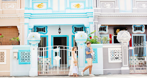 Mother and daughter walking past colorful Peranakan shophouses in Joo Chiat, Singapore, during a vibrant and candid family photography session