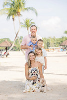 Family sitting together on the beach surrounded by greenery in Singapore during a natural and candid family photoshoot