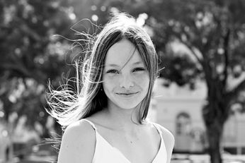 Young woman smiling in black and white portrait outdoors in garden setting