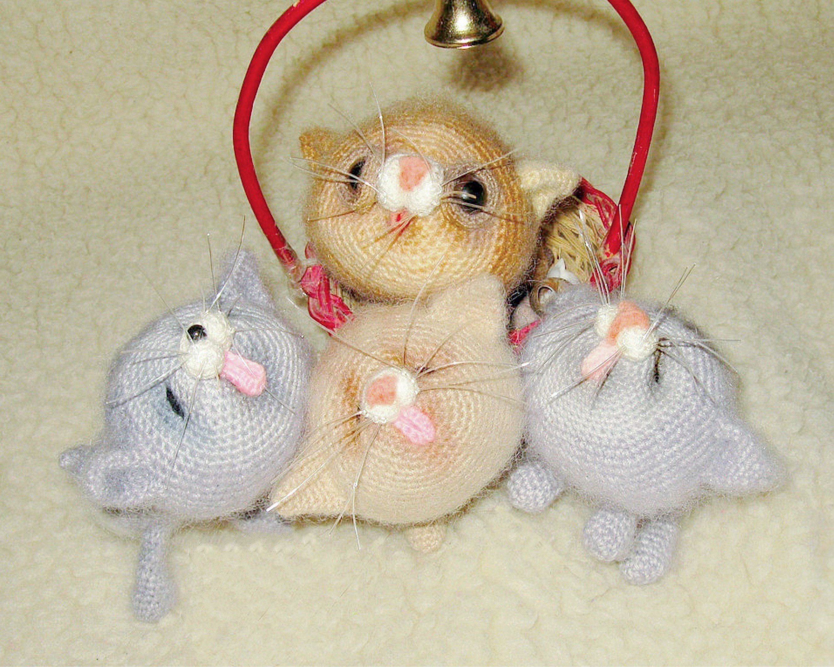 Gehäkelte graue und braune Katzenbabies mit rosa Zunge im Korb
