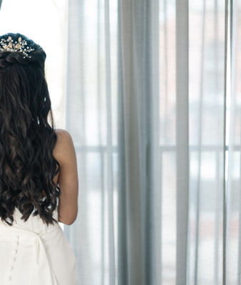 Novia de espalda mirando por la ventana en su gran día 