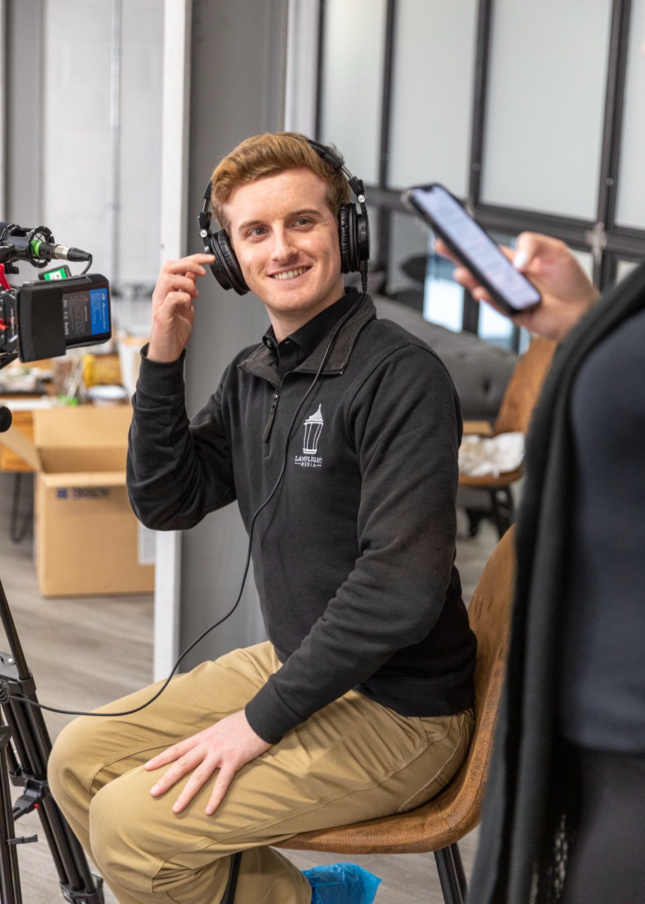 Smiling man adjusting headphones in a studio
