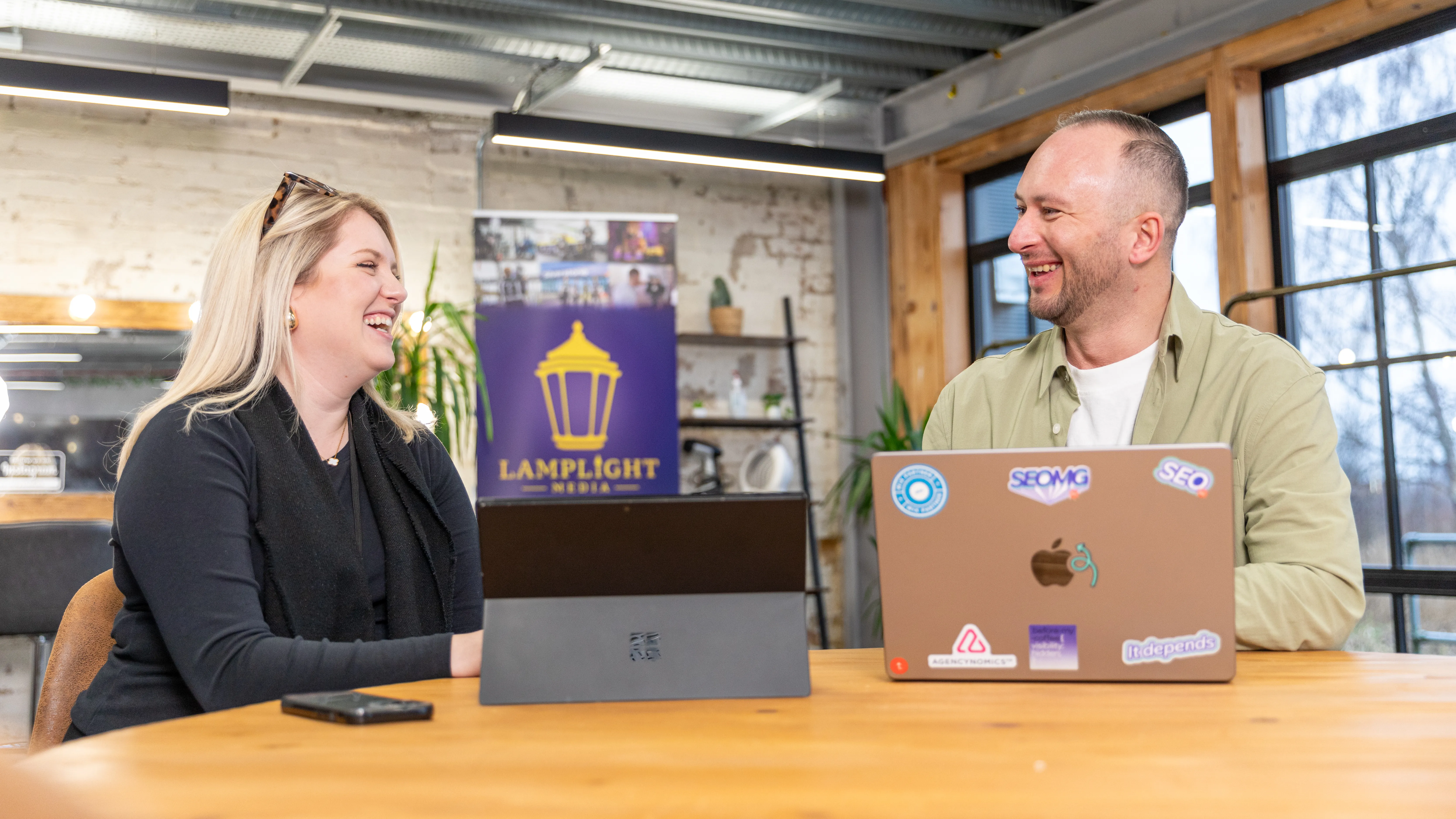 Content Works team collaborating around laptops in a creative workspace