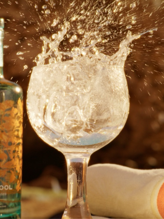 Silent Pool gin bottle next to a splashing cocktail glass