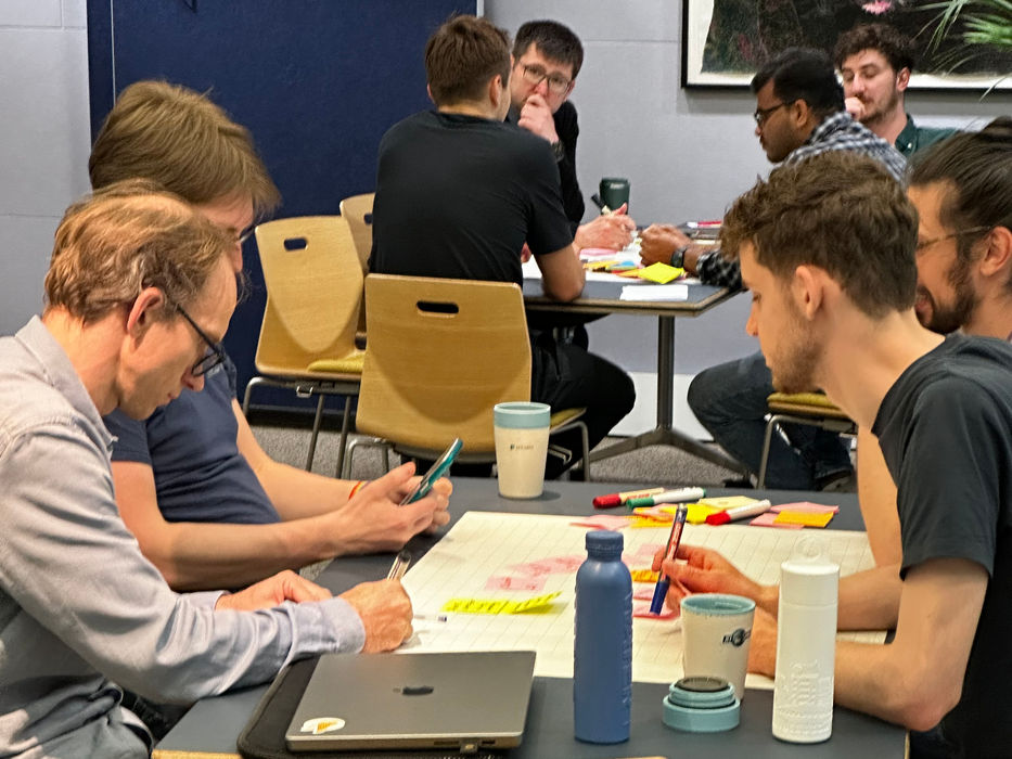 Group working together around table with sticky notes and markers