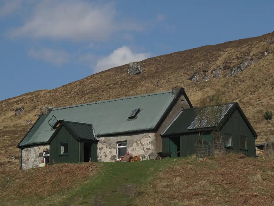 Rustic stone house on a green hillside