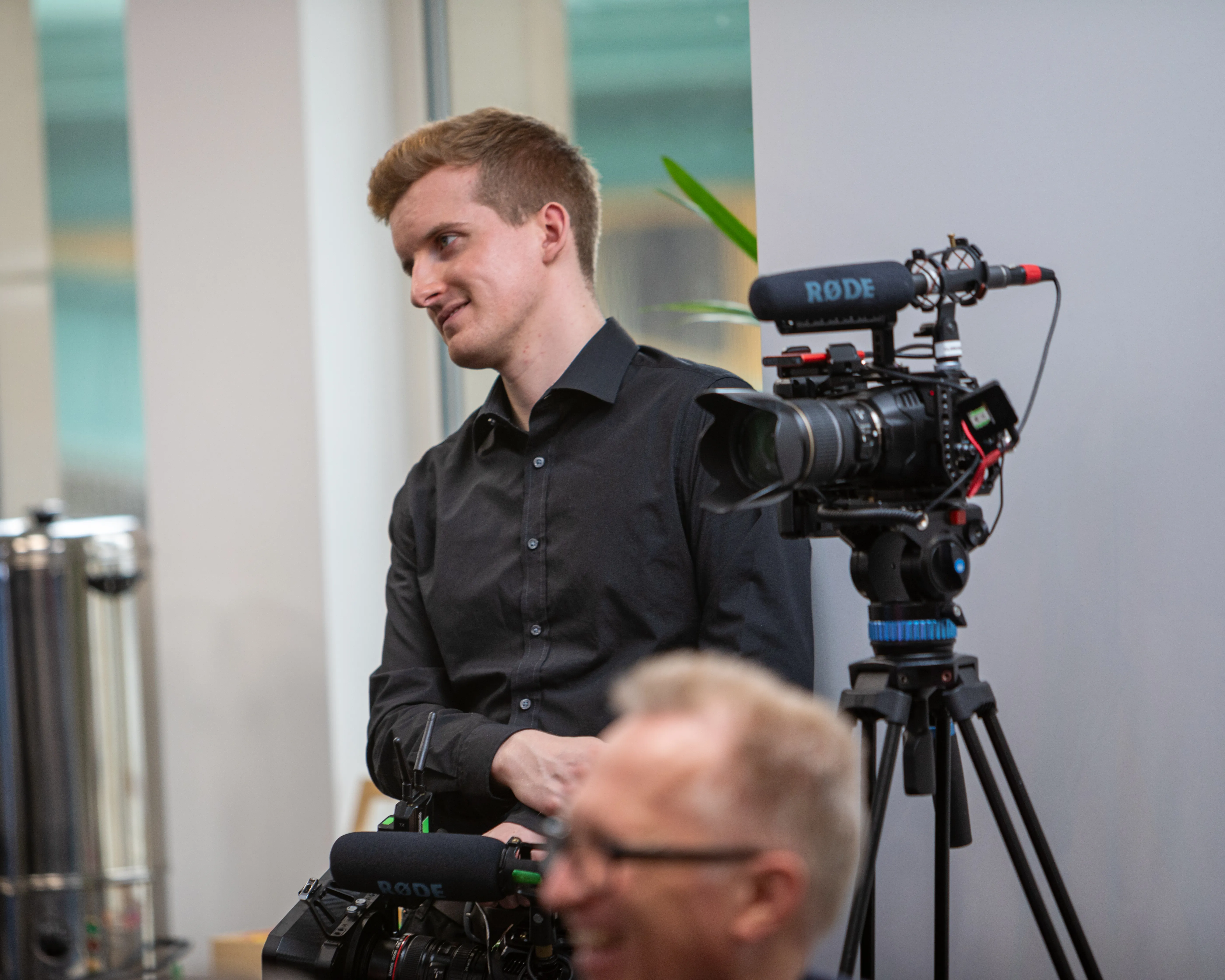 Film lighting positioned to balance the floor-to-ceiling windows during the Rakuten Symphony fireside chat