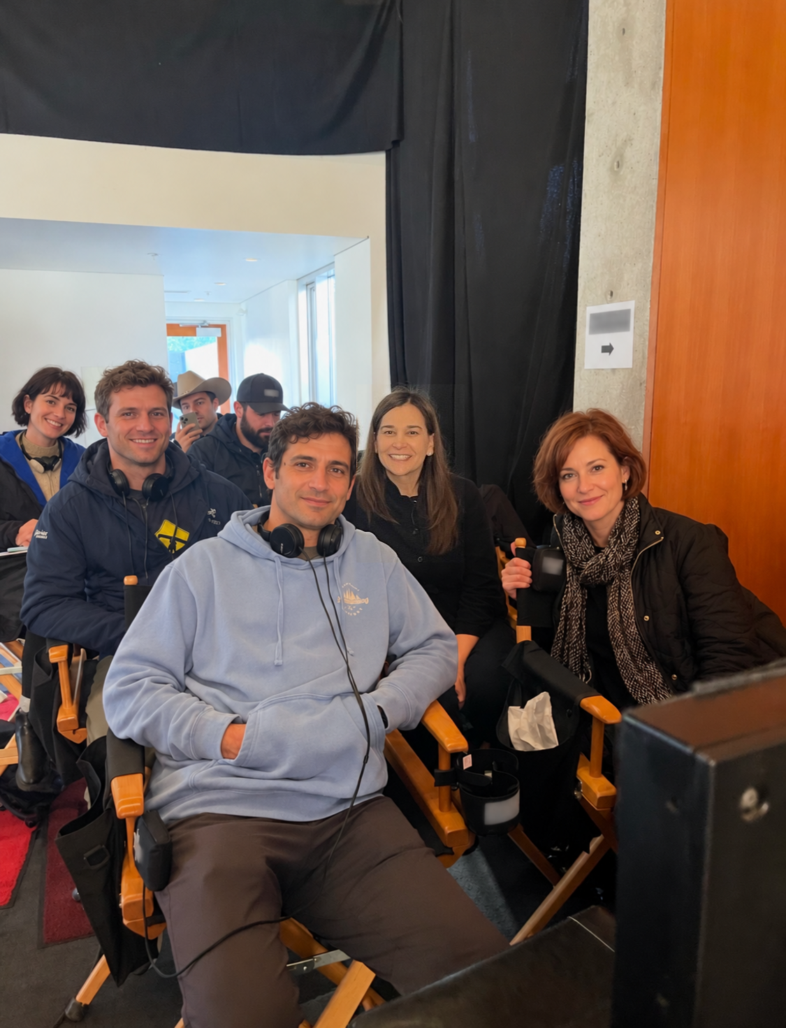 Dr. Brandy seated among a group beside production monitors.