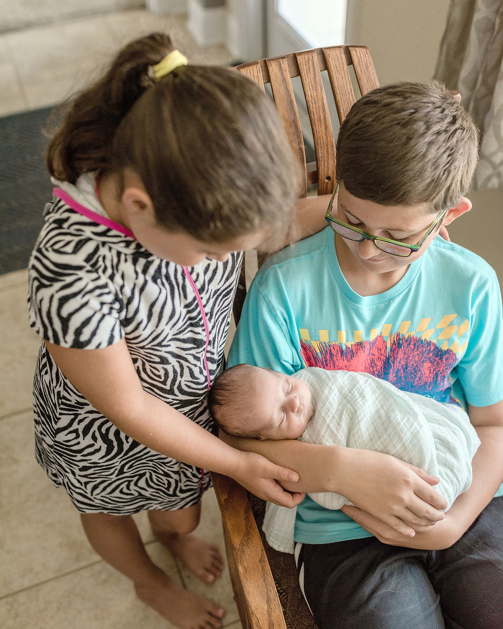 siblings holding newborn