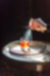 Spray into a cocktail glass in bright light