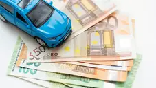 une voiture posé sur un tas de billet de banque, pour les cuations en espèces dans la location automobile