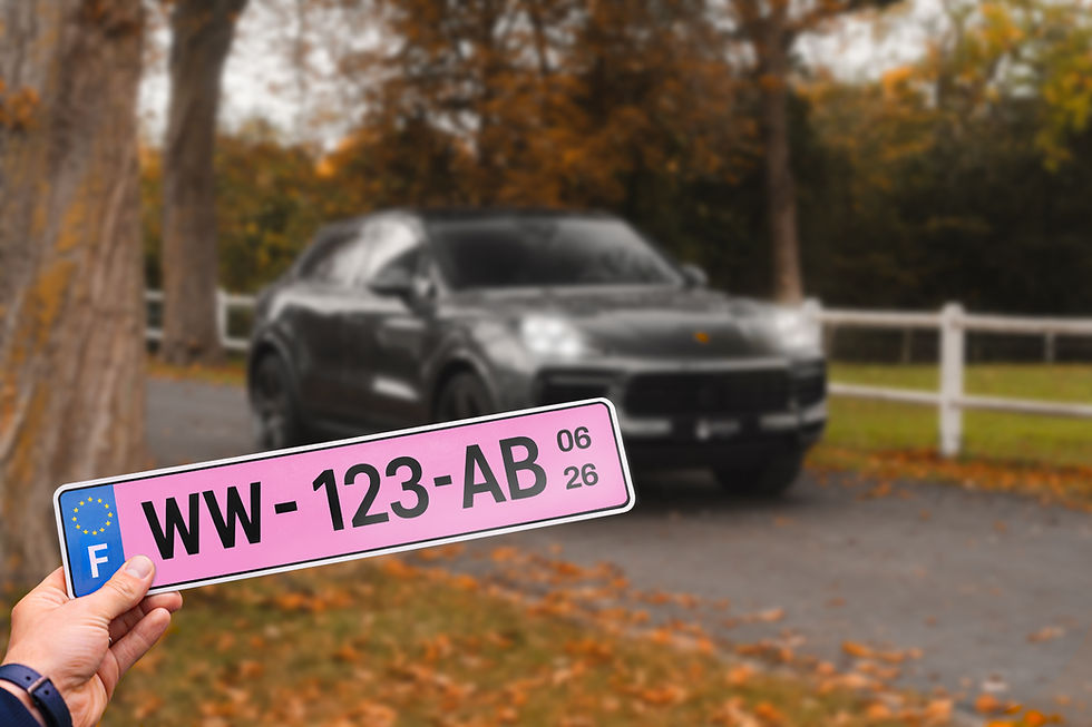 Une plaque rose d'immatriculation provisoire devant un porsche cayenne sur une route