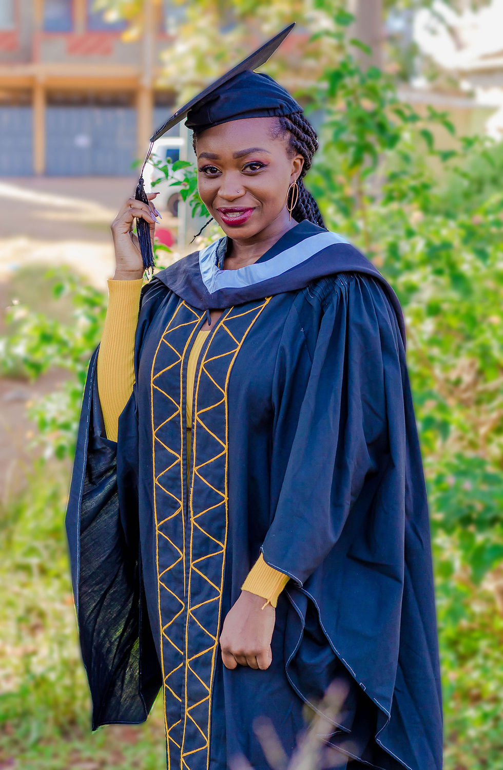 Smiling graduate in Truthvision Media academic gown