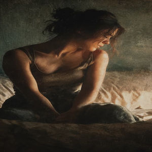 A woman sitting tensely on the edge of her bed, looking down in emotional distress, symbolizing how breakups affect the body snd nervous sytem