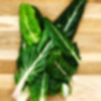 Picked Swiss chard on an oak chopping board