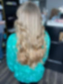 Long blonde wavy hair styled from behind in a salon.