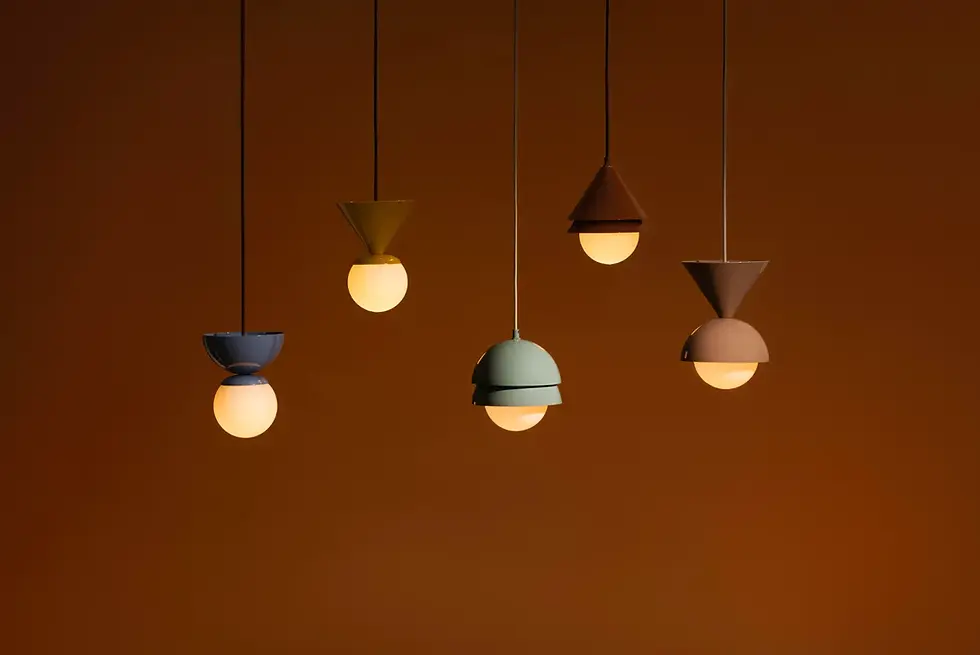 Luminaire Authentik’s New FORMA Collection
Five pendant lights with geometric designs hang against a warm brown background, emitting a soft glow. Blue, green, and brown hues.