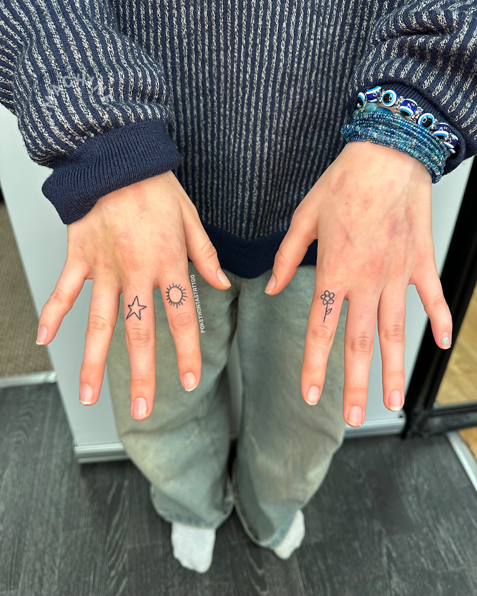 Star, sun and flower tattoos on fingers