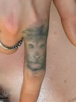 a detailed but blurry and faded lion tattoo on index finger that