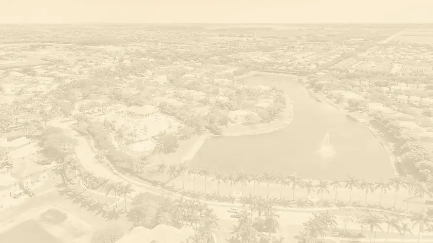 Aerial view of an upscale residential community in Homestead, Florida, with a scenic lake, palm-lined roads, and luxury homes — ideal for highlighting international real estate expertise as a Certified International Property Specialist (CIPS).