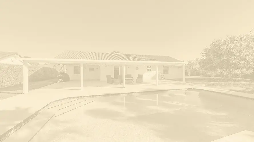 A luxury backyard view featuring a spacious covered patio with outdoor seating and a private swimming pool, representing upscale South Florida real estate.