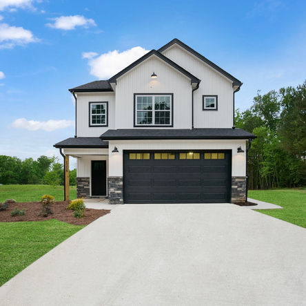 Modern two-story house with a black garage door and driveway, custom home builder north carolina