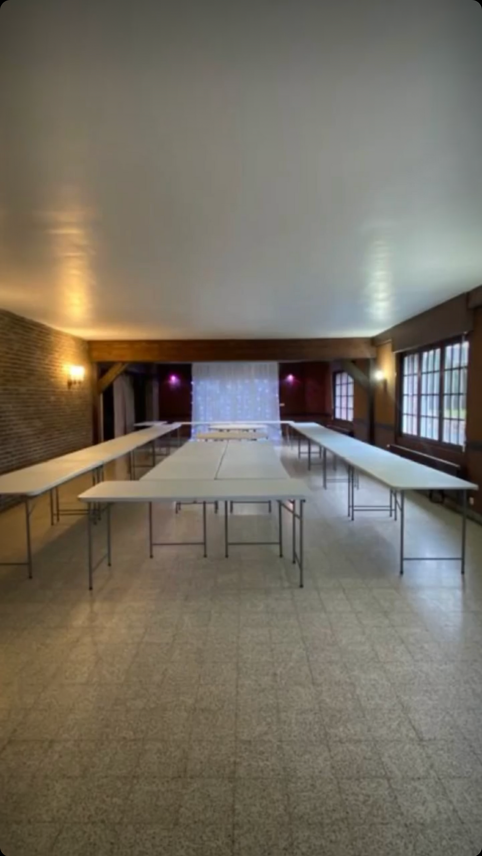 White plastic tables and chairs in a warm interior space, used as a wedding reception and creating a pleasant atmosphere.