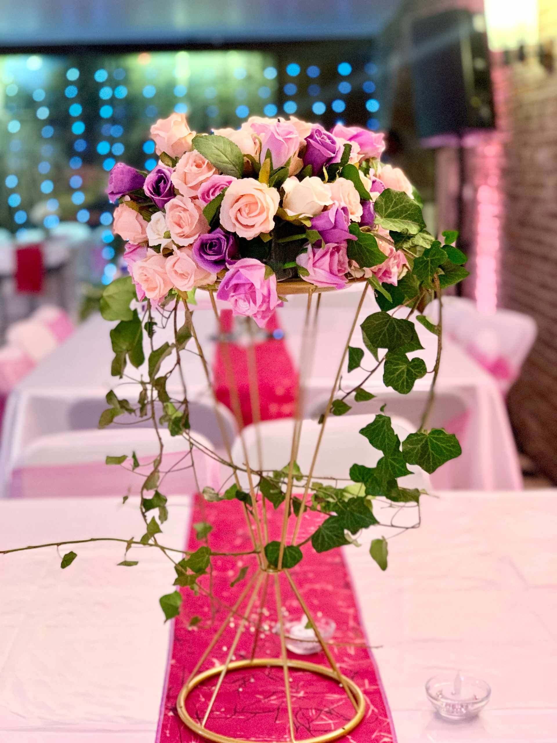 A table elegantly decorated with a bouquet of pink and purple flowers, creating a colourful and festive atmosphere and adding a touch of freshness.