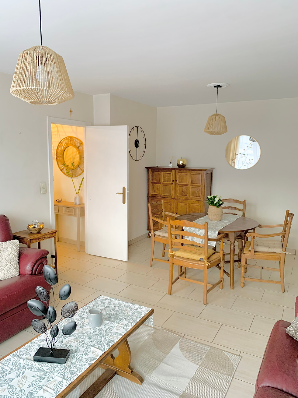 Séjour accueillant avec une table à manger et des chaises, créant une atmosphère conviviale et chaleureuse, parfait pour des moments de partage.