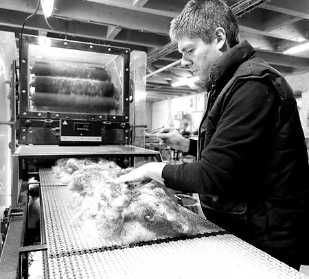 Nicolas, co-dirigeant de la Petite Filature Bretonne, travaillant à la carde.
