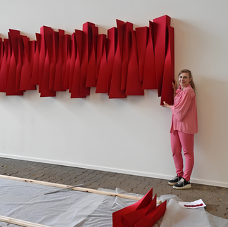 Artist Rania Schoretsaniti stood in front of one of her red artworks
