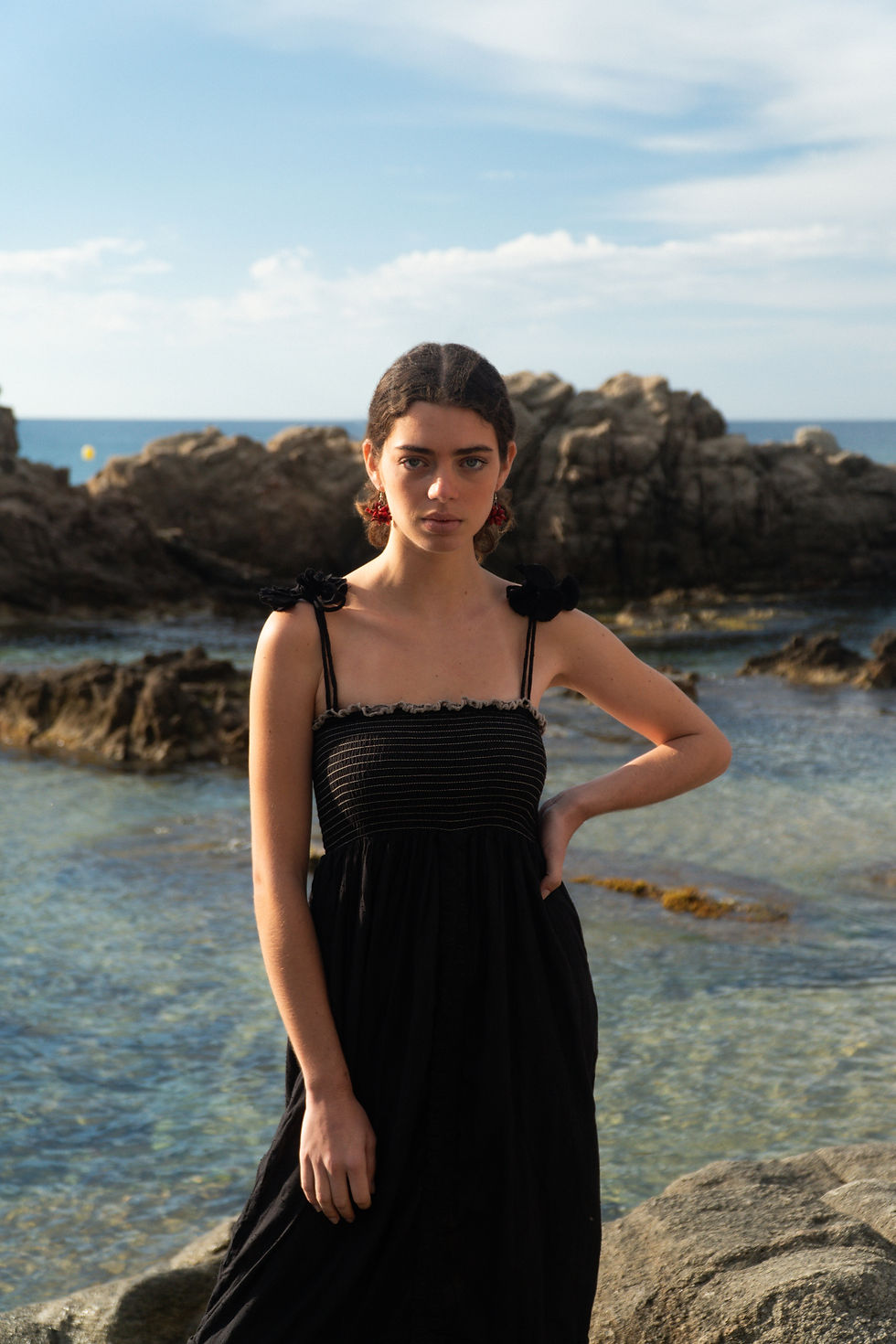 Thumbnail: Long black jacquard cotton dress with smocked top. Lace details and flower ornaments at shoulder level