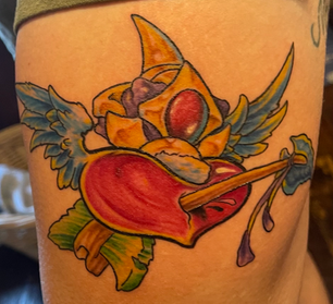 Vibrant tattoo of a winged heart pierced by an arrow