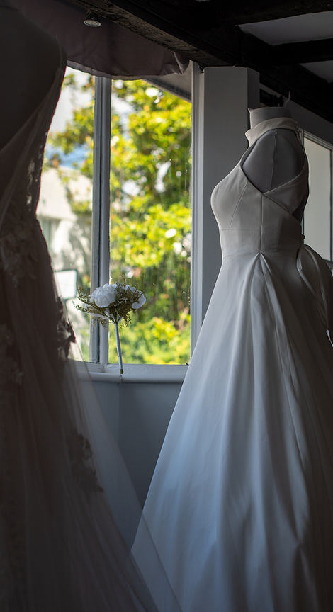 Wedding dress on mannequin in shop window with bouquet