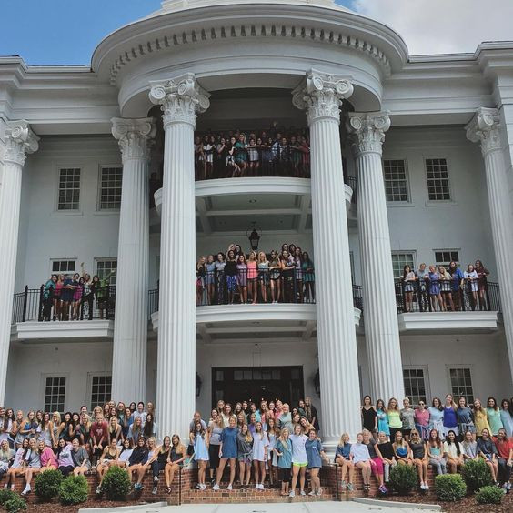 What is Alabama Rush Tok? A large white sorority house from Alabama University with a lot of sorority sisters girls standing outside.