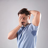 Sweaty man with stain on t-shirt against
