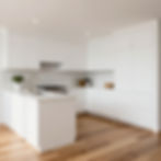 Modern white kitchen with island and wood floor