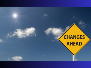 A 'Changes Ahead' road sign against a bright blue sky, representing organisational change and the challenges of leading teams through transition.