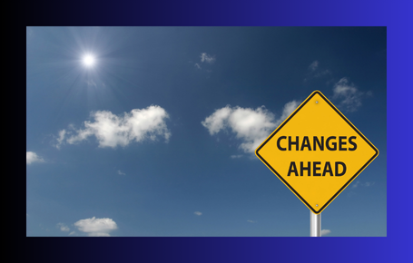 A 'Changes Ahead' road sign against a bright blue sky, representing organisational change and the challenges of leading teams through transition.