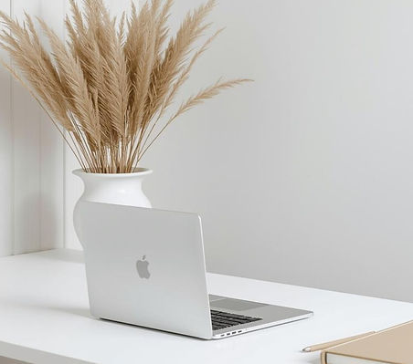 Beautiful airy white office with white timber desk, large vase with pampas in the corner,