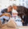 Two women window shopping for a handbag on a city street.