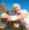 Smiling senior woman playing tennis after retirement.