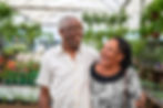 Smiling senior couple walking in a garden greenhouse